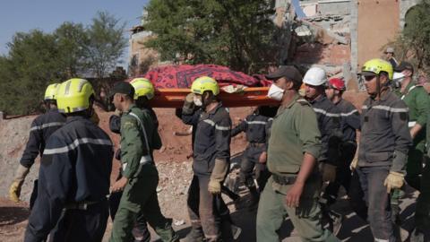 A rescue team carries the body of an earthquake victim