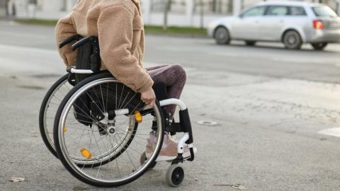 Person in a wheelchair crossing the road