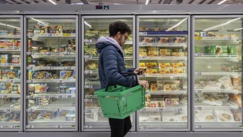 Man shopping in a supermarket while on a budget