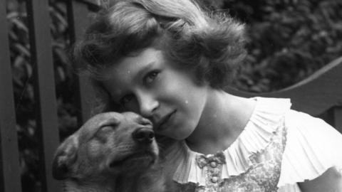 Queen Elizabeth with a dog during her chilhood