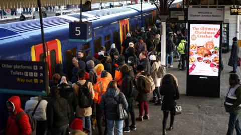 Commuters board a train at Clapham Junction