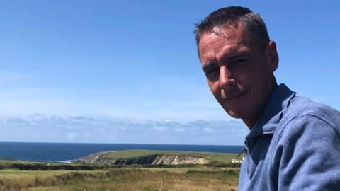 Shane Scannell with cliffs and the sea in the background