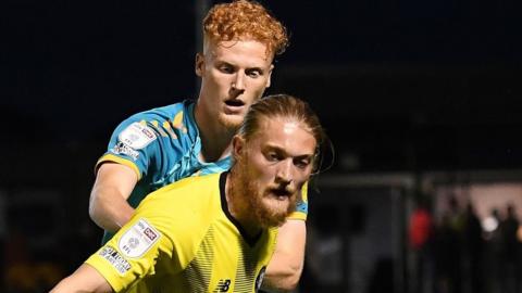 Luke Armstrong of Harrogate Town and Ryan Haynes of Newport County battle for possession