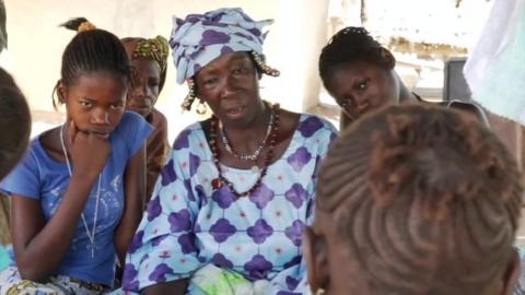 Egge Kande sitting with village girls.