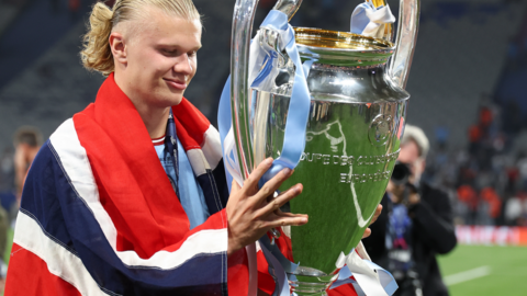 Manchester City's Erling Haaland with a Norway flag holding the Champions League trophy