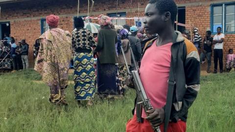 A Patriots Union for the Liberation of Congo (UPLC) militiaman stands guard at a polling station in Kalunguta, Beni Territory, North-Kivu Province, Eastern Democratic Republic of Congo, on December 20, 2023.
