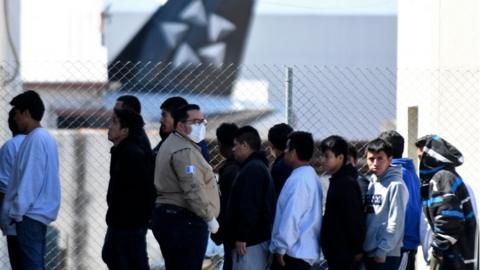 Deportees queue at an air force base in Guatemala on 12 March