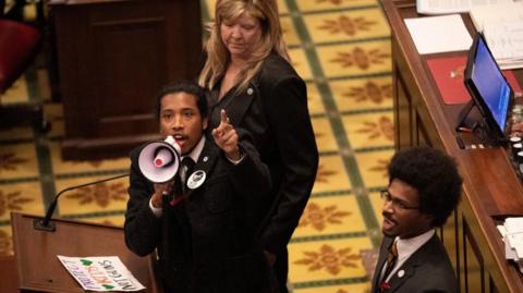 Tennessee State Representative Justin Jones, standing with Rep. Justin Pearson and Rep. Gloria Johnson, calls on his colleagues to pass gun control legislation from the well of the House Chambers during the legislative session, three days after the mass shooting at The Covenant School, at the State Capitol in Nashville, Tennessee, U.S. March 30, 2023