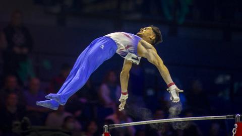 Jake Jarman performs on the high bar