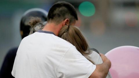 Man comforting a teenager after the Manchester Arena attack