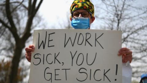A healthcare worker protests paid sick leave