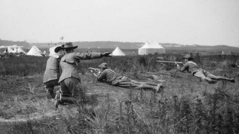 Soldiers lying on the ground holding rifles and taking aim during training in the Second Boer War period