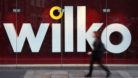 A person walks past a Wilko store