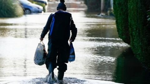A person makes their way through flood water in Wraysbury, Berkshire