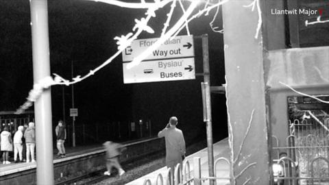 man jumping across railway track