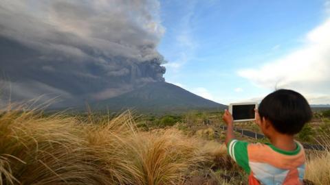 boy and volcano in Indonesia