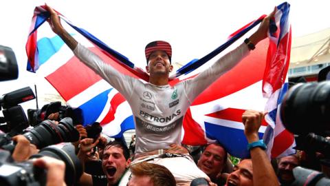 Lewis Hamilton celebrates with the Mercedes team after winning his third World Championship