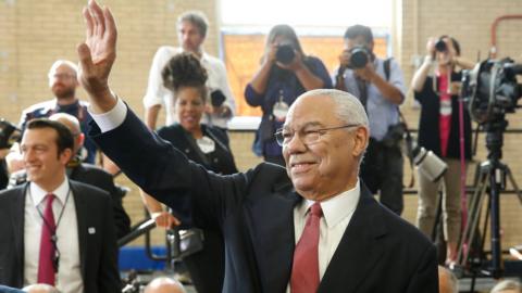 Former US Secretary of State Colin Powell waves before arrival of President Barack Obama at Benjamin Banneker Academic High School in Washington DC on October 17, 2016.