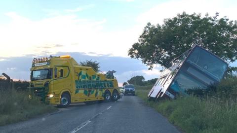 Bus in a ditch and recovery vehicle