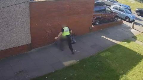 The officer appearing to kick the boy