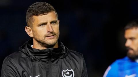 Portsmouth boss John Mousinho walks off the pitch at Fratton Park following his side's exit from the EFL Cup