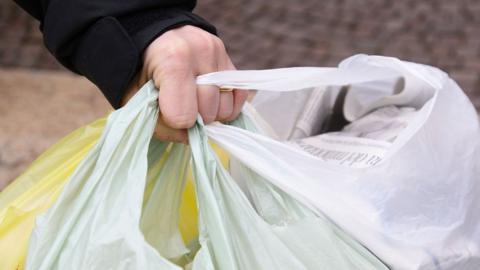 Hand holding plastic bags