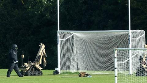 bomb disposal robots next to goalposts