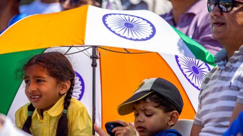 Young fans take some shade in the Oval's stands during day four of the ICC World Test Championship Final match between India and Australia