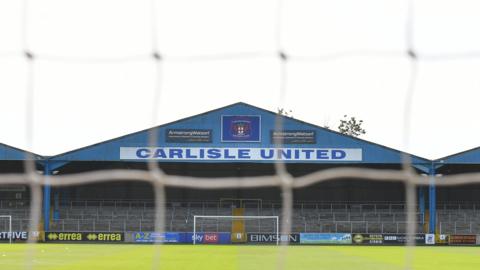 Carlisle United's Warwick Road terrace viewed through a goalnet