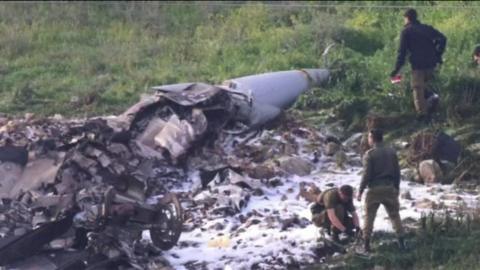 Men inspect the site of the crashed jet