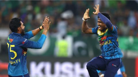 Two Sri Lanka cricketers high-five and celebrate a wicket against Pakistan as they win the Asia Cup