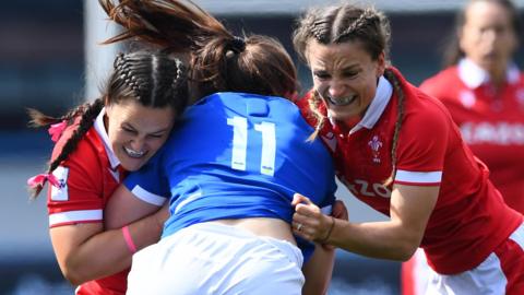 Maria Magatti of Italy is tackled by Ffion Lewis and Jasmine Joyce