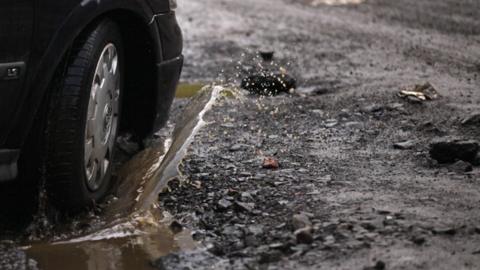 A car driving through a pothole