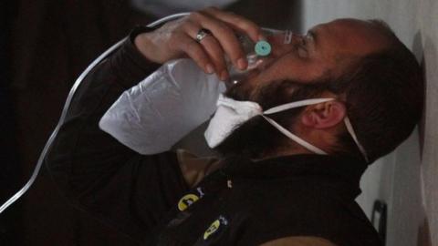 A civil defence member breathes through an oxygen mask, after what rescue workers described as a suspected gas attack in the town of Khan Sheikhoun in rebel-held Idlib, Syria April 4, 2017