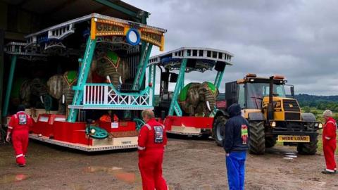 Carnival floats being put away into a large shed