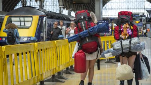 Festival-goers wait for a train at Paddington Station