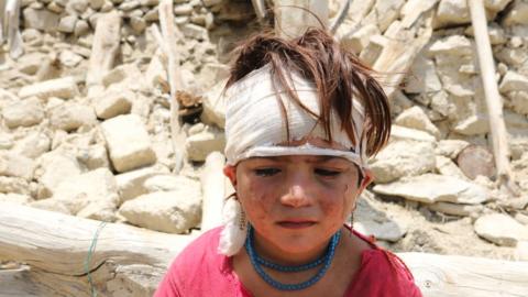 Child outside destroyed home in Khost area