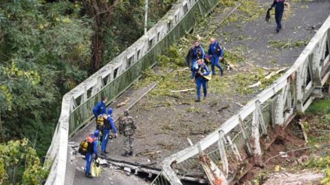 Rescuers walk on a suspension bridge which collapsed on 18 November 18 in Mirepoix-sur-Tarn, near Toulouse, south-west France