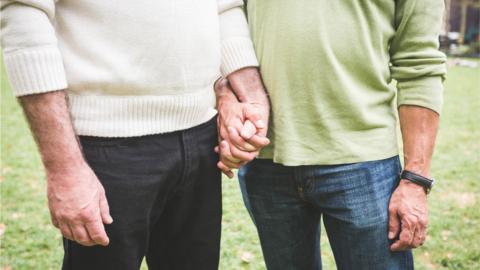 Two men holding hands