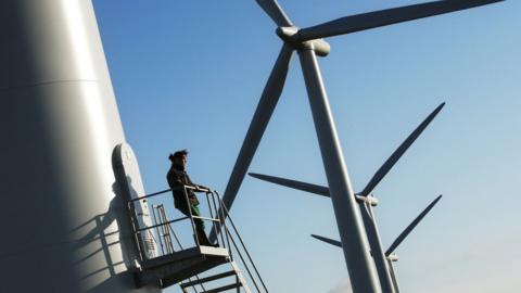 man in front of wind turbine