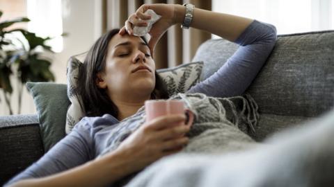 sick woman lying on sofa