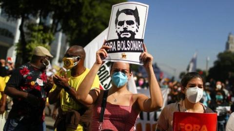 A person holds a sign reading "Bolsonaro out" during a protest calling for the impeachment of Brazil's President Jair Bolsonaro in Rio de Janeiro, Brazil, on 3 July 2021