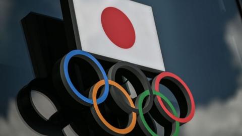 Olympic Rings and the Japanese flag are seen outside the Olympic Museum in Tokyo on August 24, 2020.