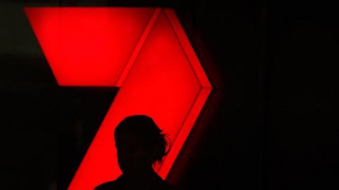 A silhouette in front of the Seven logo