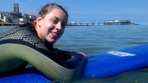 Natasha Abrahart on a paddleboard in the sea, smiling