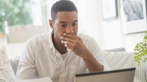 A person looking stressed while looking at bills