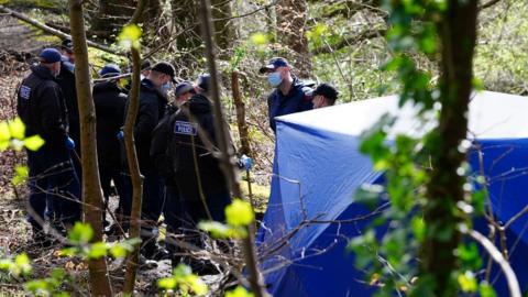 Police officers by a forensic tent at Kersal Dale, near Salford