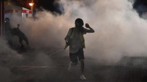 A protester runs away from tear gas