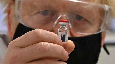 Boris Johnson holding a Covid vaccine