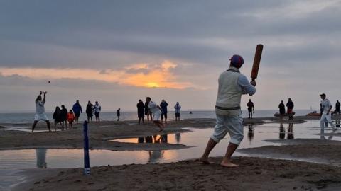Brambles sandbar cricket match at sunrise